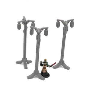 Three grey 3D-printed miniature lampposts on a white background, shown next to a painted figure for scale