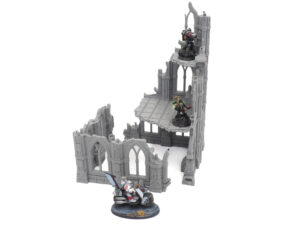 Grey 3D-printed gothic ruin tabletop gaming terrain, shown with miniature figures for scale