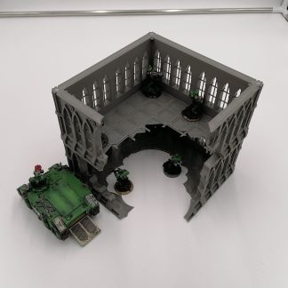 A large stackable ruined gothic themed tabletop wargaming centre piece with a rhino transport next to it