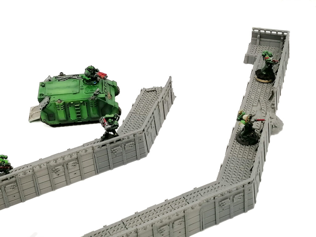 Modular grey 3D printed trench wall terrain for tabletop wargaming, shown with miniatures for scale