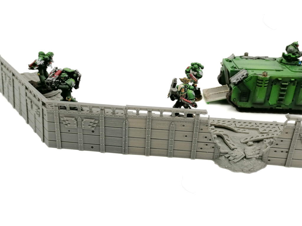 Grey 3D-printed sci-fi trench wall with a breached section, shown with painted miniature soldiers for scale