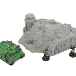 Grey 3D-printed tabletop wargaming terrain of a rocky bunker, displayed with painted green miniatures for scale