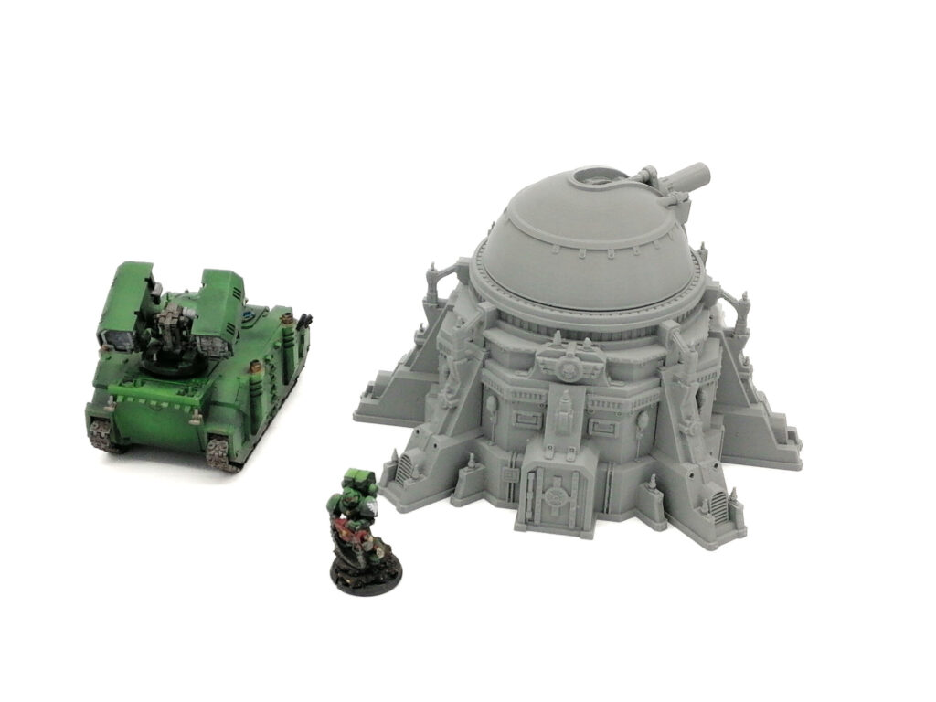Grey 3D-printed sci-fi dome bunker terrain piece shown next to miniature tank and soldier figures for scale