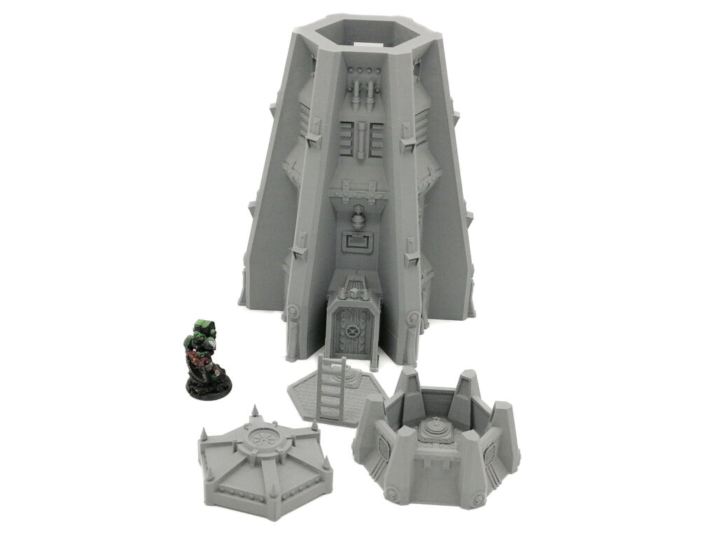 Grey 3D-printed sci-fi tower terrain set for tabletop gaming, shown next to a miniature figure for scale
