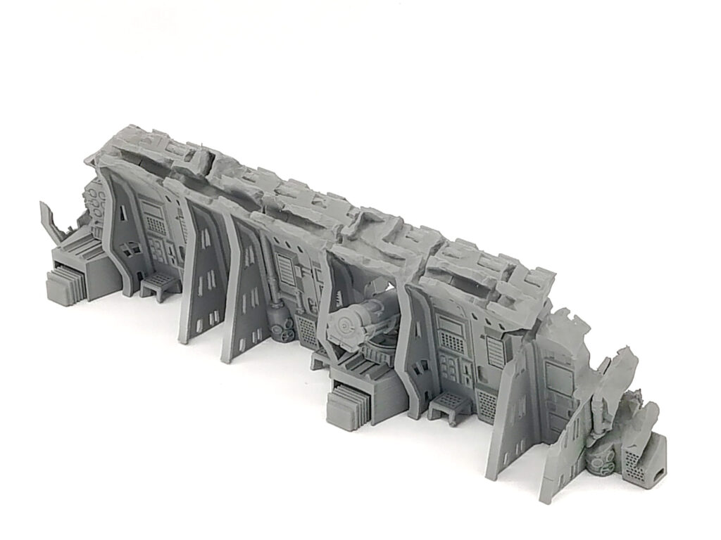Grey 3D-printed miniature sci-fi fortification wall with control panels and a weapon station for tabletop gaming