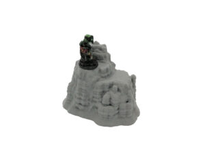 Grey 3D-printed rocky outcrop terrain miniature for tabletop gaming, shown with a painted sci-fi figure for scale