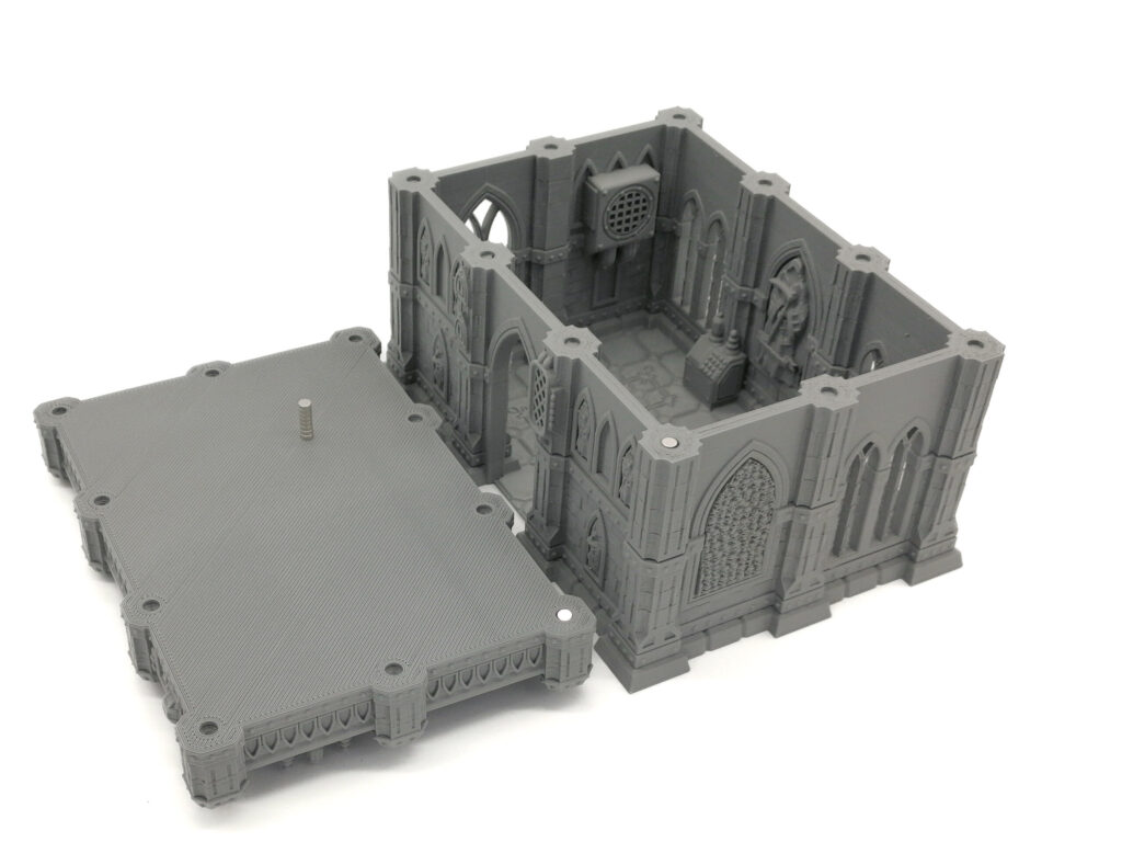 Grey 3D-printed gothic-style building miniature with a detached roof panel showing the detailed interior