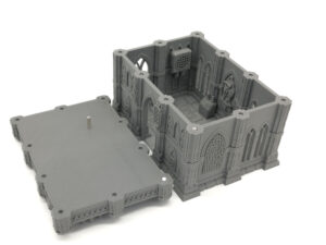 Grey 3D-printed gothic-style building miniature with a detached roof panel showing the detailed interior