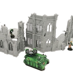 Grey 3D-printed gothic ruin terrain set for tabletop gaming, shown with a green miniature tank and soldiers