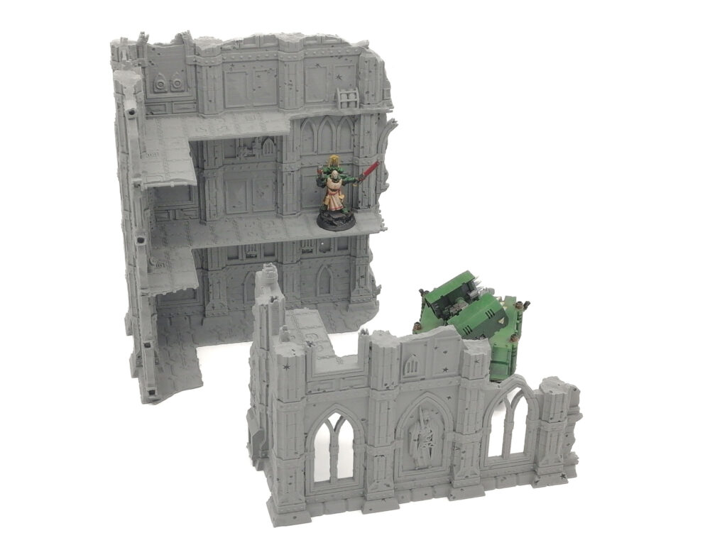 Grey 3D-printed gothic ruins terrain for tabletop wargaming, showing a multi-level building and ruined wall section