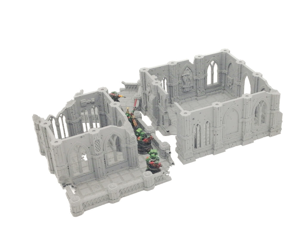 Grey 3D-printed gothic ruin tabletop terrain shown with miniature soldiers on a white background