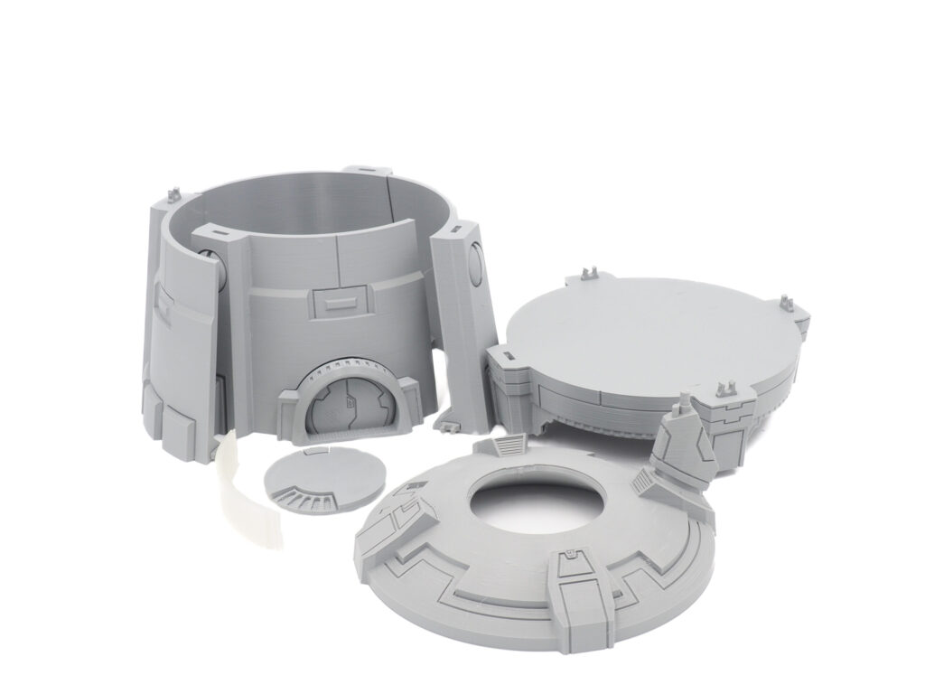 Grey 3D-printed plastic components for an unassembled sci-fi tabletop terrain building