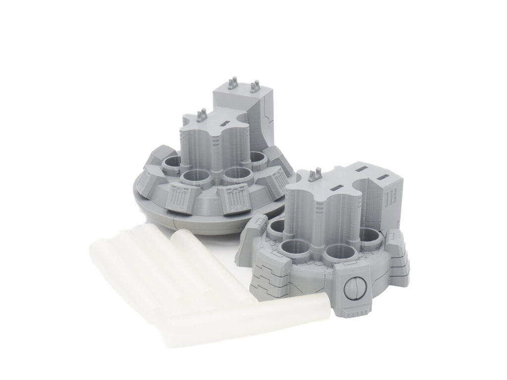 Grey 3D-printed sci-fi miniature components with semi-translucent plastic rods on a white background