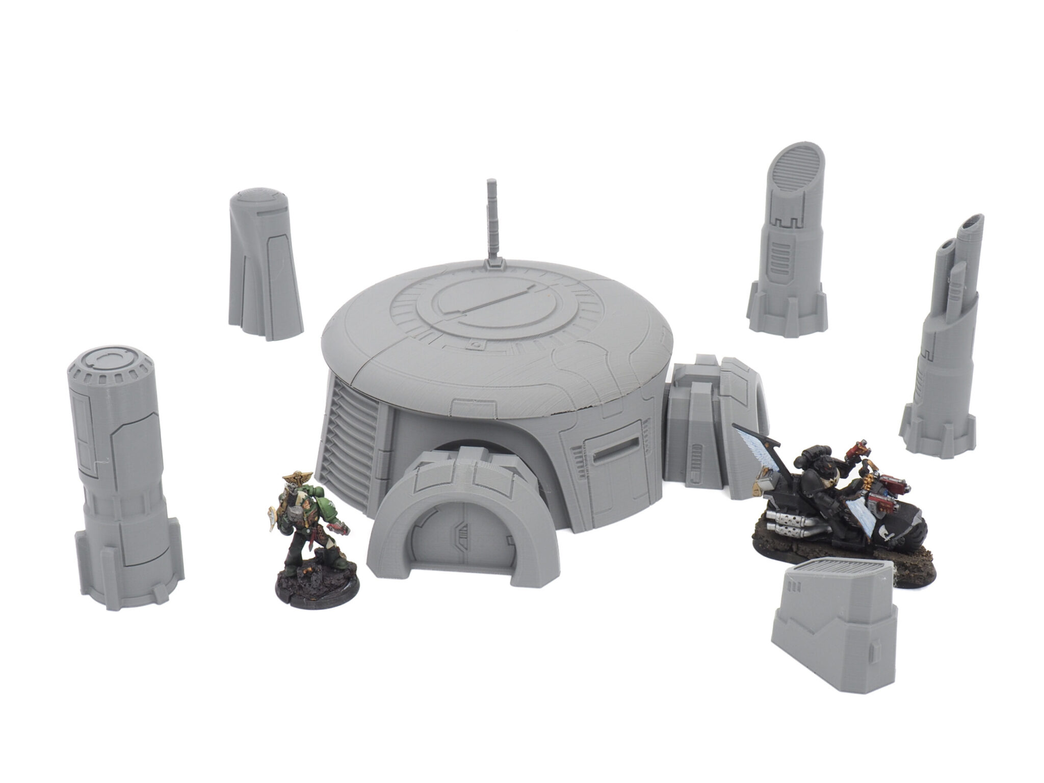 Grey 3D-printed sci-fi bunker and pillars tabletop terrain set, shown with painted miniatures for scale