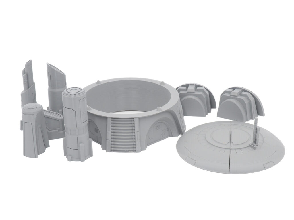 A collection of grey 3D-printed sci-fi tabletop miniature terrain pieces on a white background