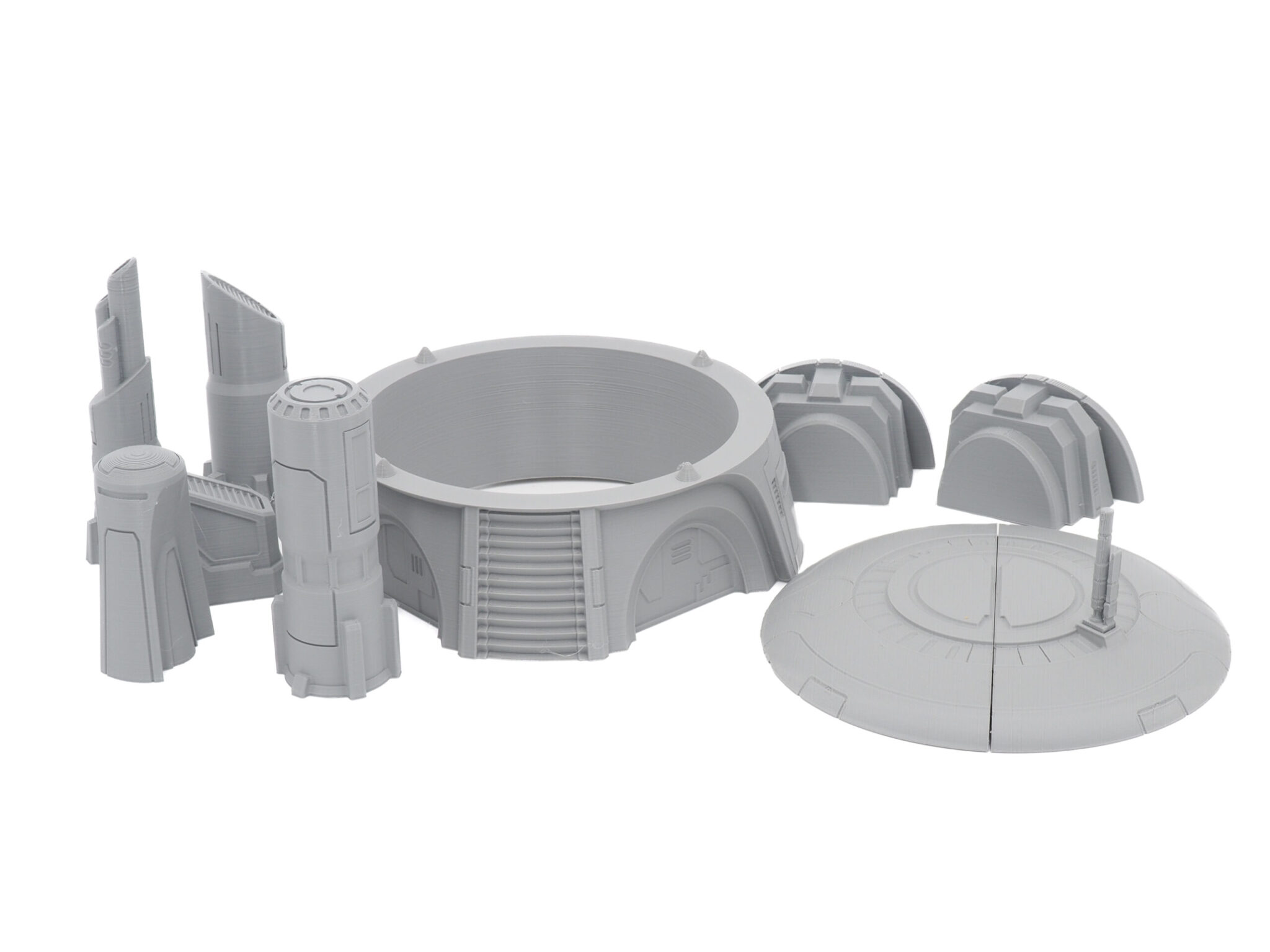 A collection of grey 3D-printed sci-fi tabletop miniature terrain pieces on a white background