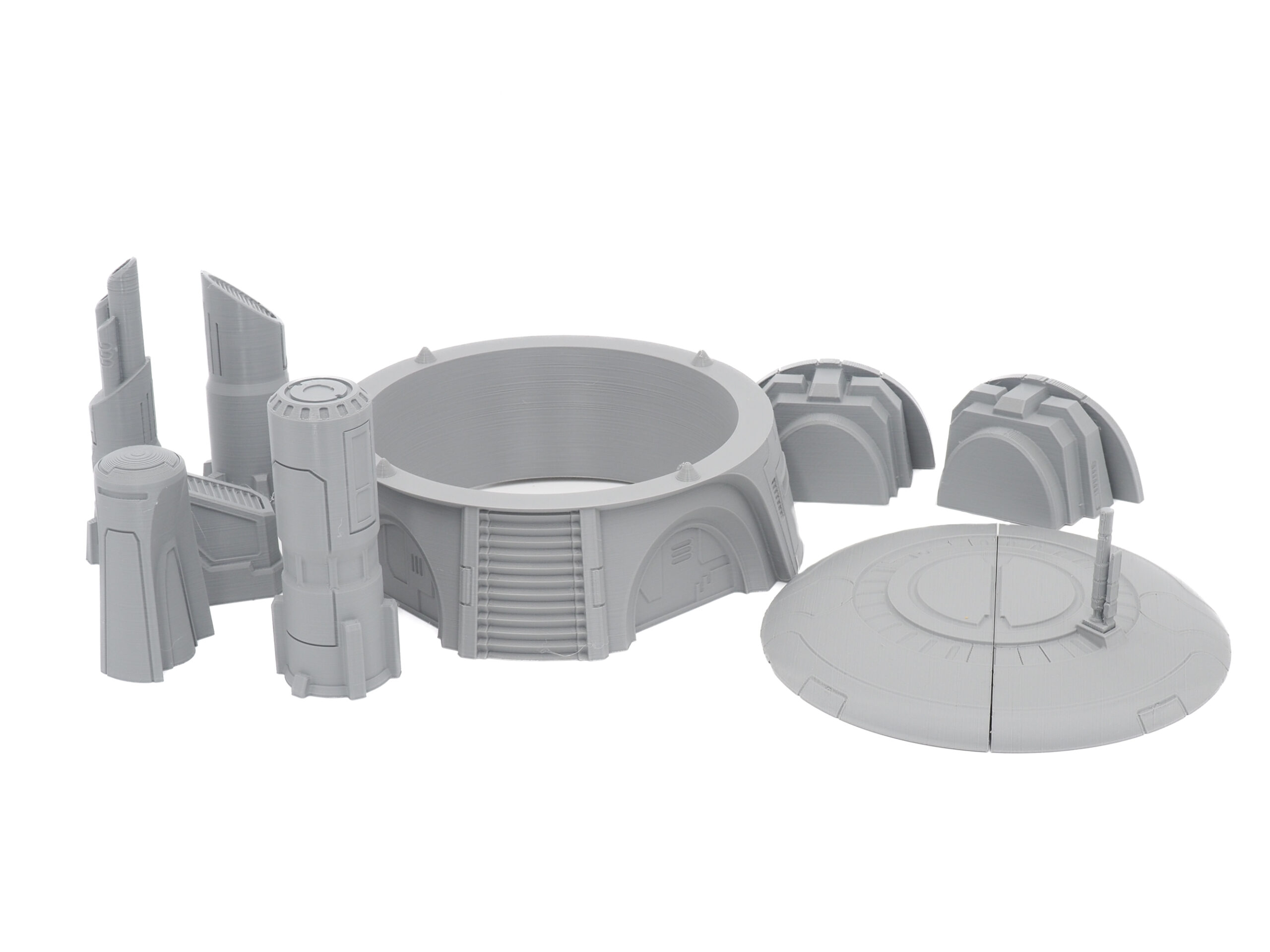 A collection of grey 3D-printed sci-fi tabletop miniature terrain pieces on a white background