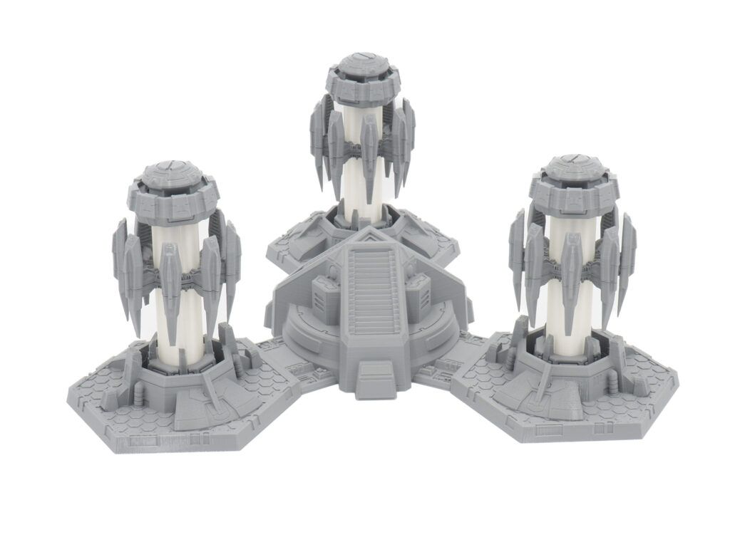 3D-printed grey and white sci-fi tabletop terrain featuring three connected towers with hexagonal bases