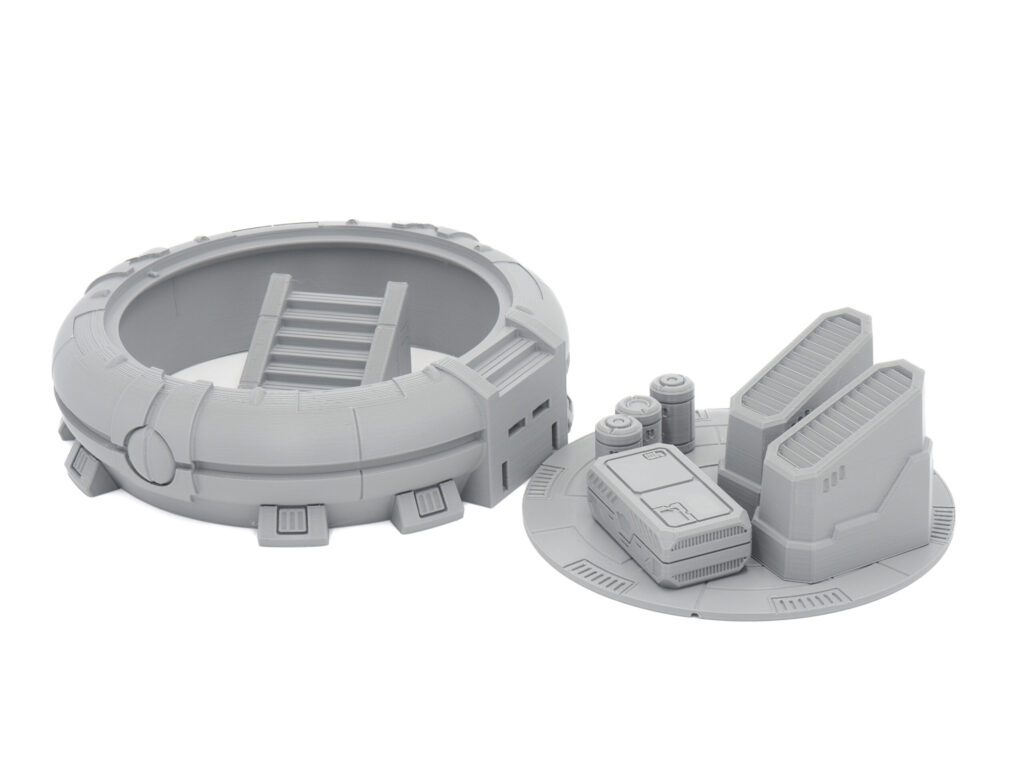 Grey 3D-printed sci-fi tabletop terrain featuring a circular hatch with a ladder and a platform with cargo crates