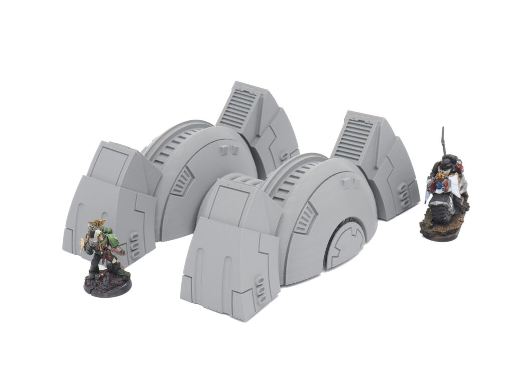 Grey 3D-printed futuristic generator terrain pieces for tabletop gaming, shown with miniatures for scale