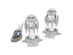 Two 3D-printed sci-fi tower terrain pieces shown next to a painted miniature biker for scale