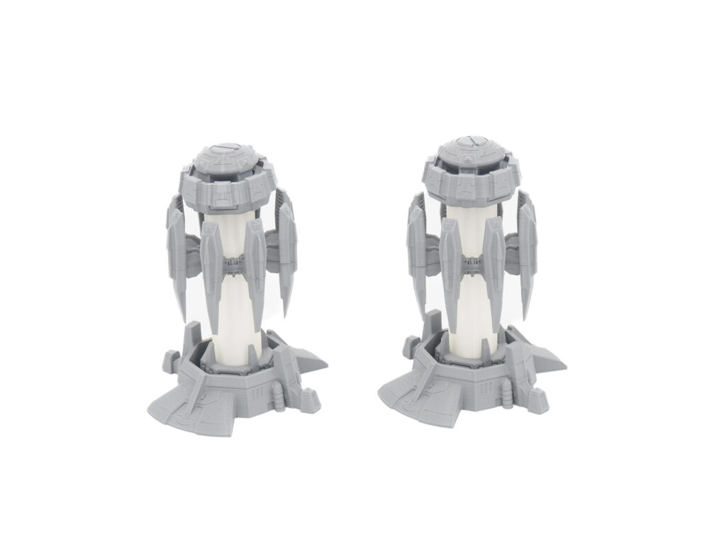 Two grey and white 3D-printed sci-fi power generator models side by side on a plain white background