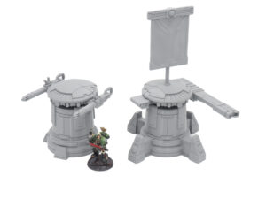 Two grey 3D-printed sci-fi turrets, one with cannons and one with a banner, next to a painted miniature for scale