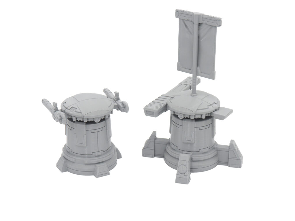 Two grey 3D-printed sci-fi miniatures: a small defense turret and an objective marker with a banner