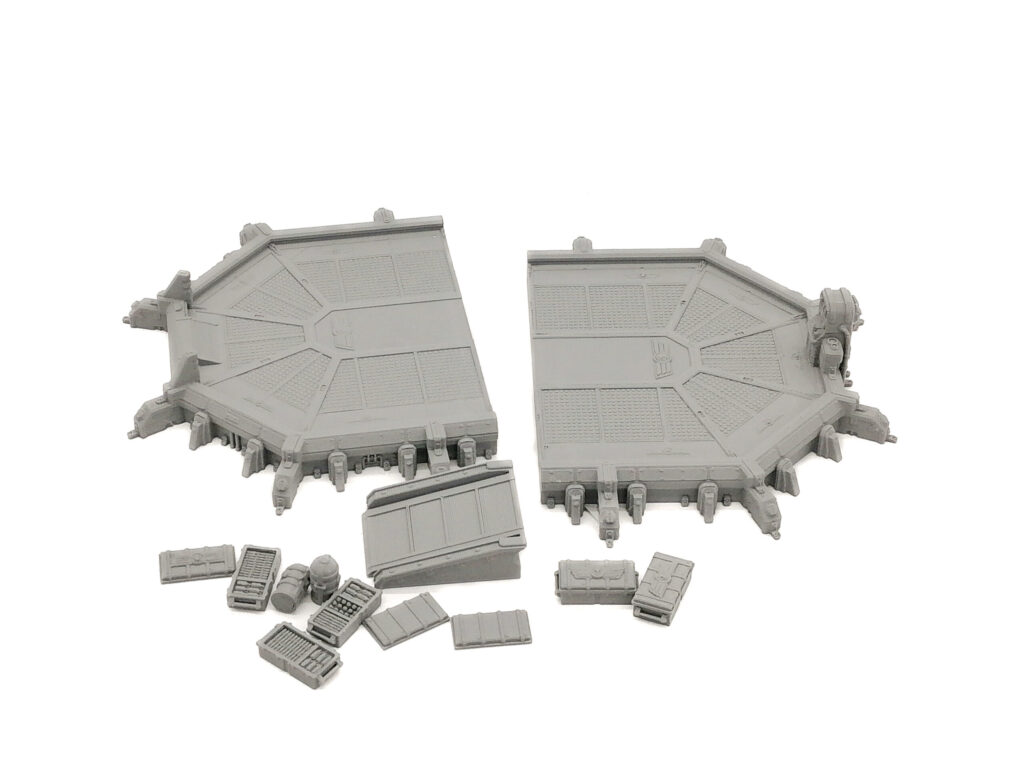 Grey 3D-printed tabletop miniature terrain set featuring landing pad segments, a ramp, and cargo crates