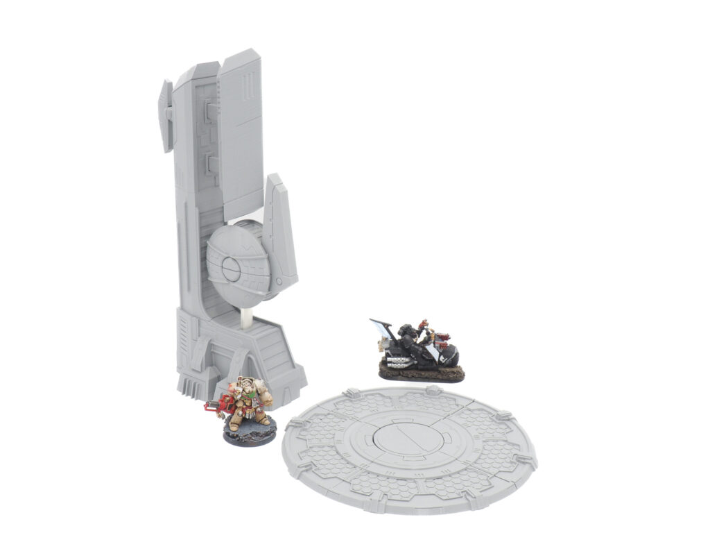 Grey 3D-printed sci-fi terrain tower and circular platform, shown with miniature figures for scale