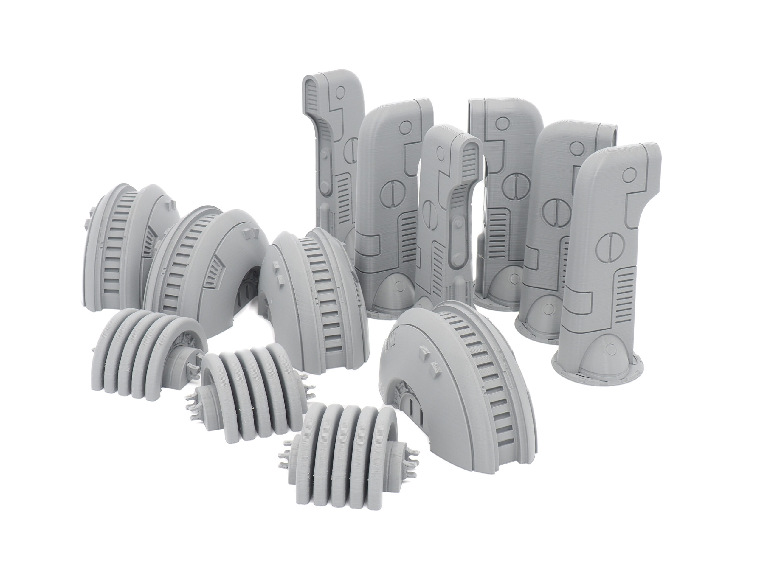 Grey 3D-printed sci-fi miniature terrain pieces, including pillars and power generators, on a white background