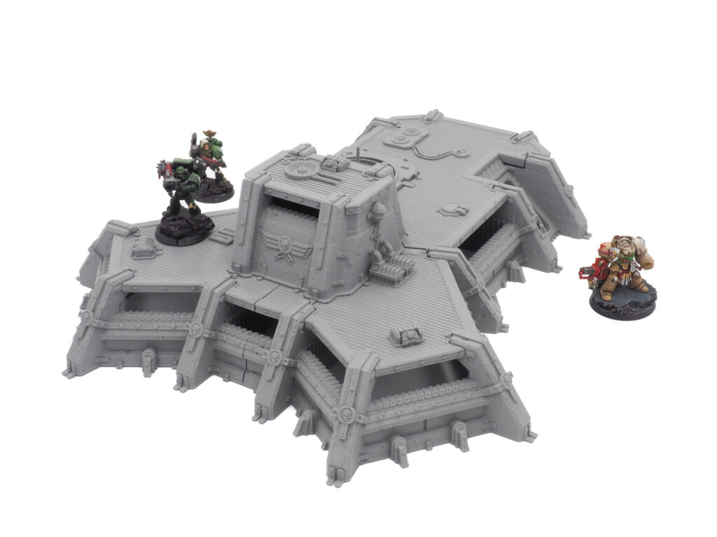 Grey 3D-printed sci-fi bunker terrain piece for tabletop wargaming, shown with miniature soldiers for scale