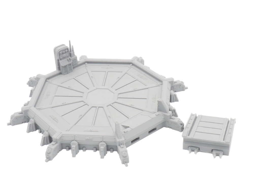 Unpainted grey 3D-printed tabletop terrain featuring an octagonal landing platform with a console and separate crate