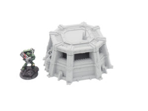 Grey 3D-printed sci-fi bunker terrain model next to a painted miniature soldier for scale
