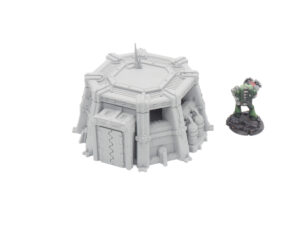 Grey 3D-printed sci-fi bunker terrain model next to a painted miniature figure for scale