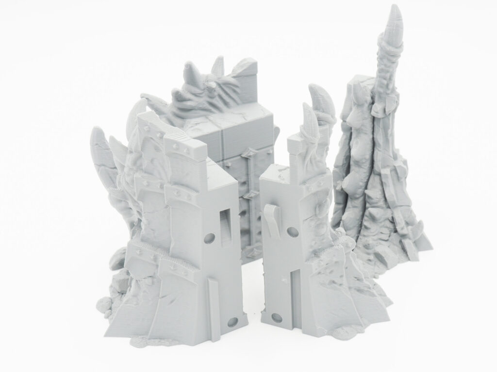 Grey 3D-printed fantasy ruins and spire miniatures for tabletop gaming
