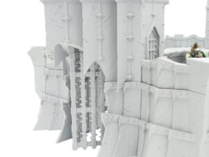 3D-printed grey fantasy castle gatehouse model with a portcullis, designed for tabletop wargaming