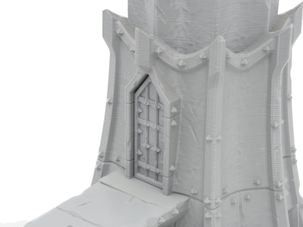 Grey 3D-printed miniature fantasy tower, showing a detailed doorway with textured filament layer lines