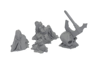 Grey 3D-printed tabletop gaming terrain pieces featuring three rocky formations and a skull with an embedded battleaxe