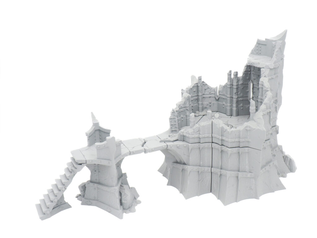 Grey 3D-printed tabletop gaming terrain featuring a ruined stone tower, connecting bridge and stairs