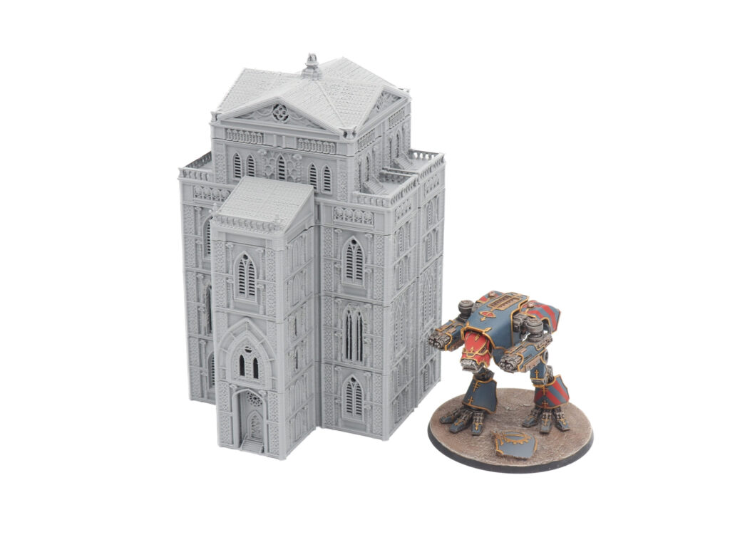 Grey 3D-printed gothic building miniature next to a painted sci-fi mech figure for scale
