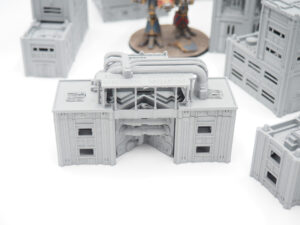 Grey 3D-printed industrial building terrain piece with exposed pipes for tabletop wargaming