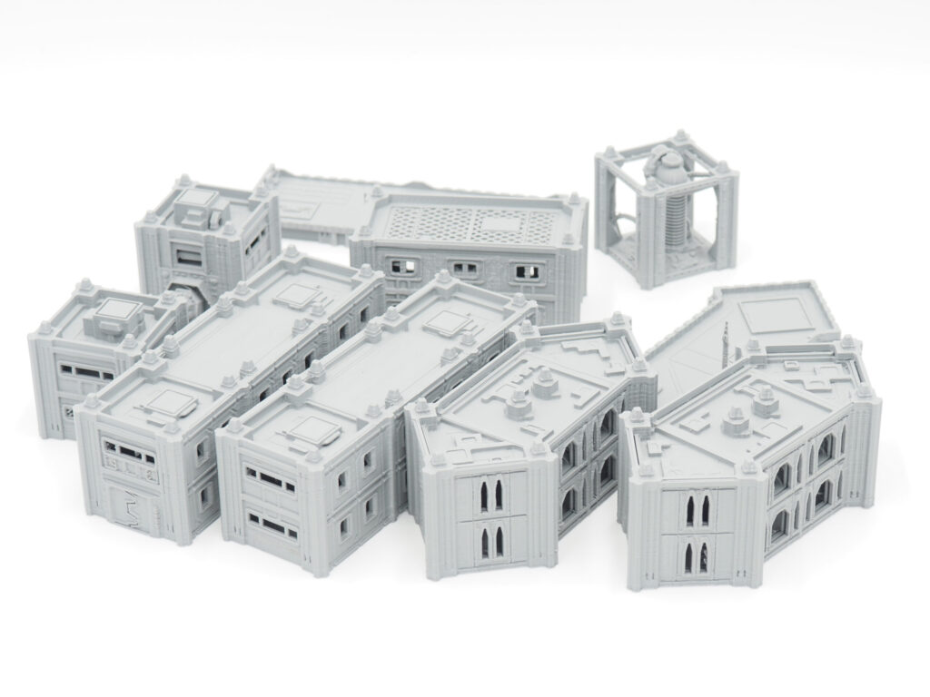 Modular grey 3D-printed sci-fi miniature buildings for tabletop gaming on a white background
