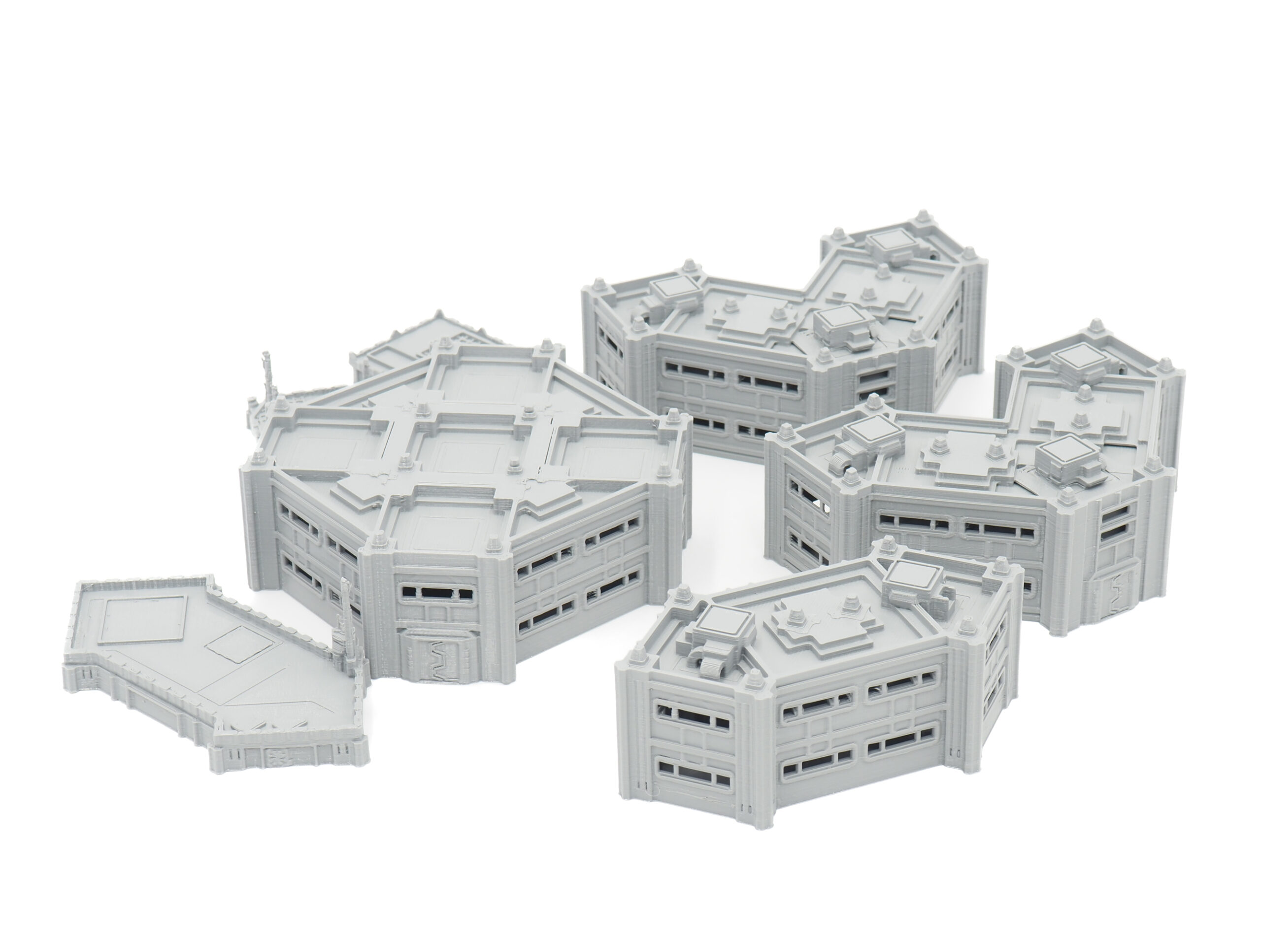 Grey 3D-printed modular sci-fi building terrain miniatures for tabletop gaming, arranged on a white background