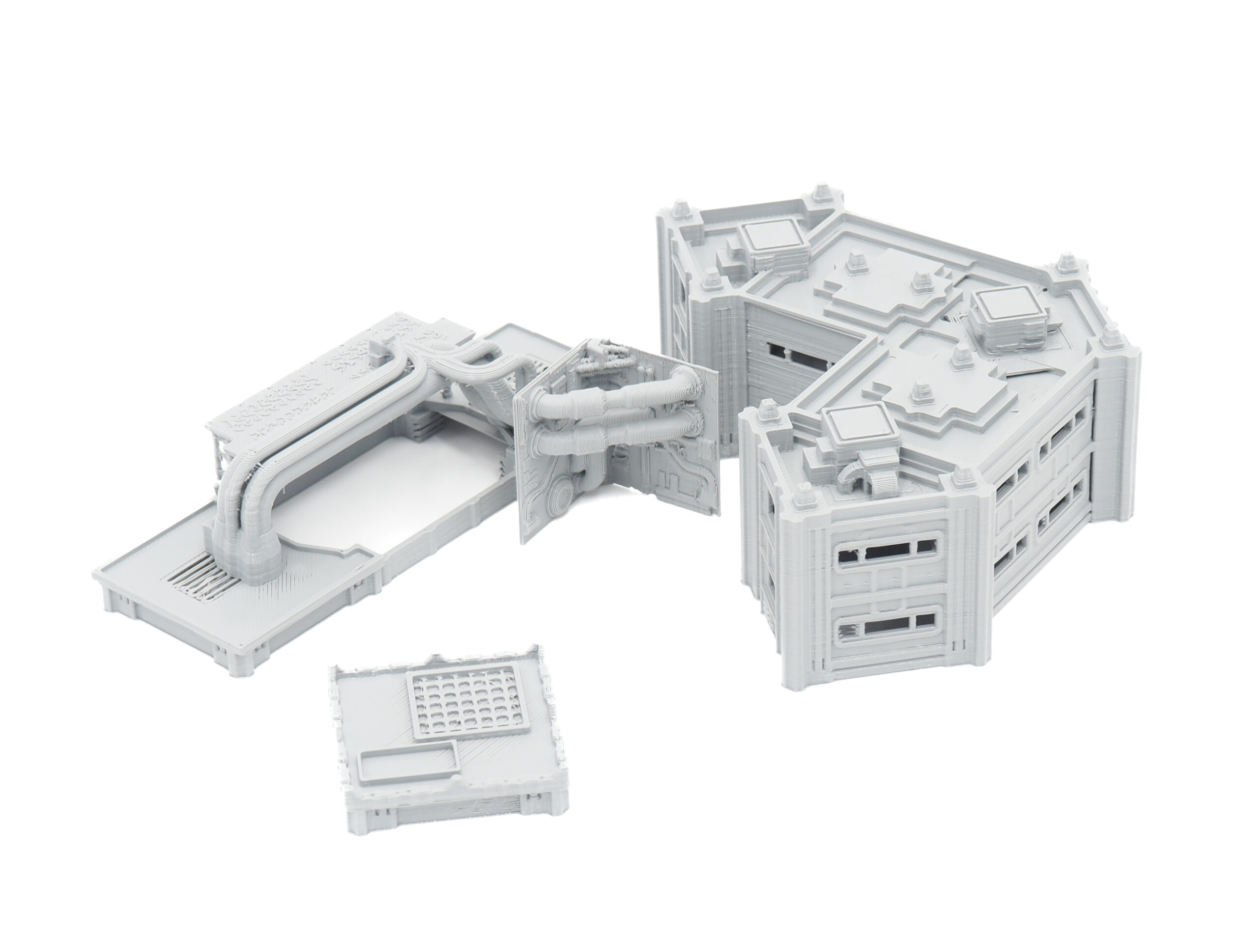 Grey 3D-printed sci-fi modular building and industrial pipe terrain pieces for tabletop gaming