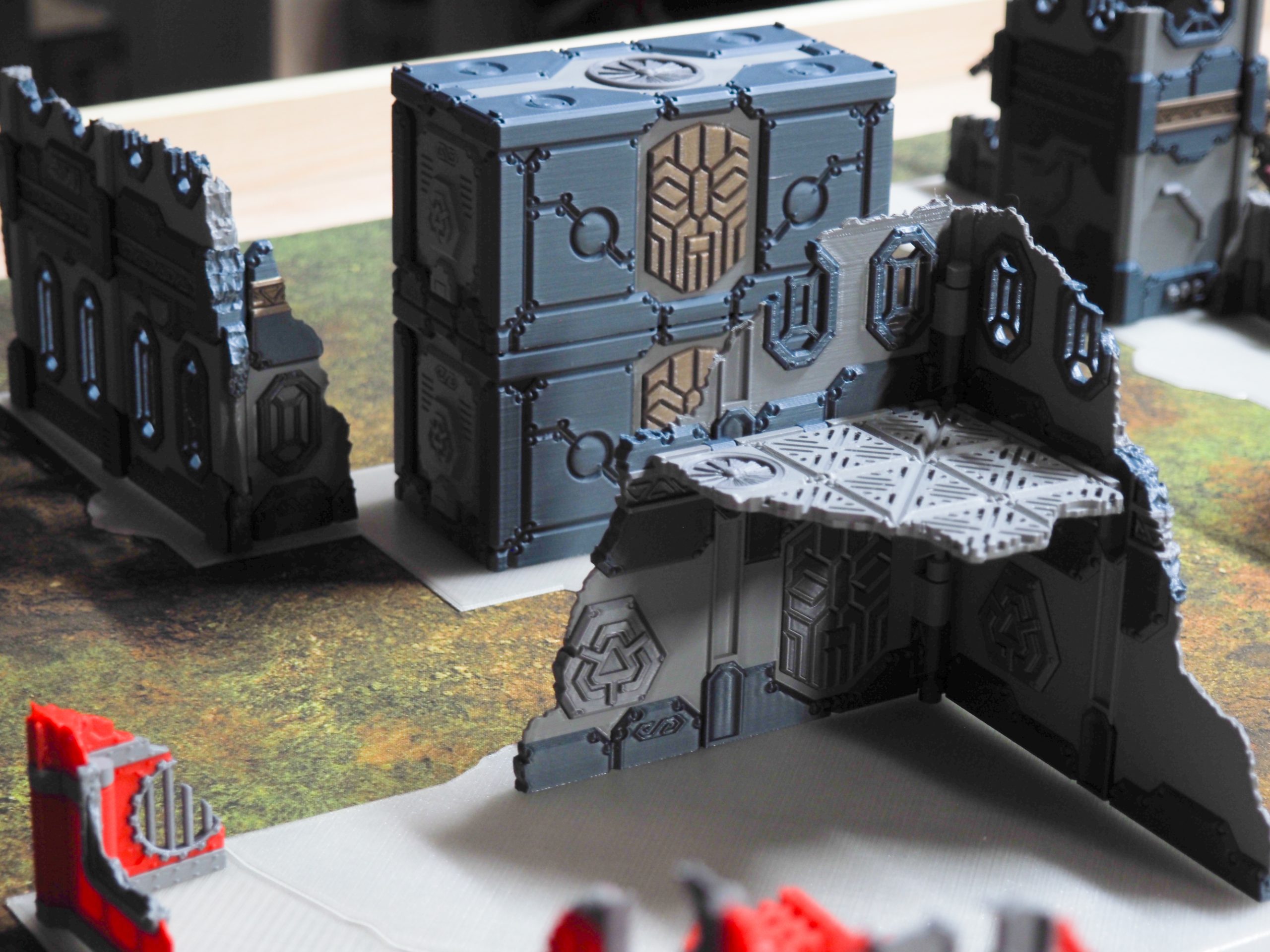 3D-printed modular sci-fi terrain featuring ruined walls, platforms, and stacked crates for tabletop wargaming