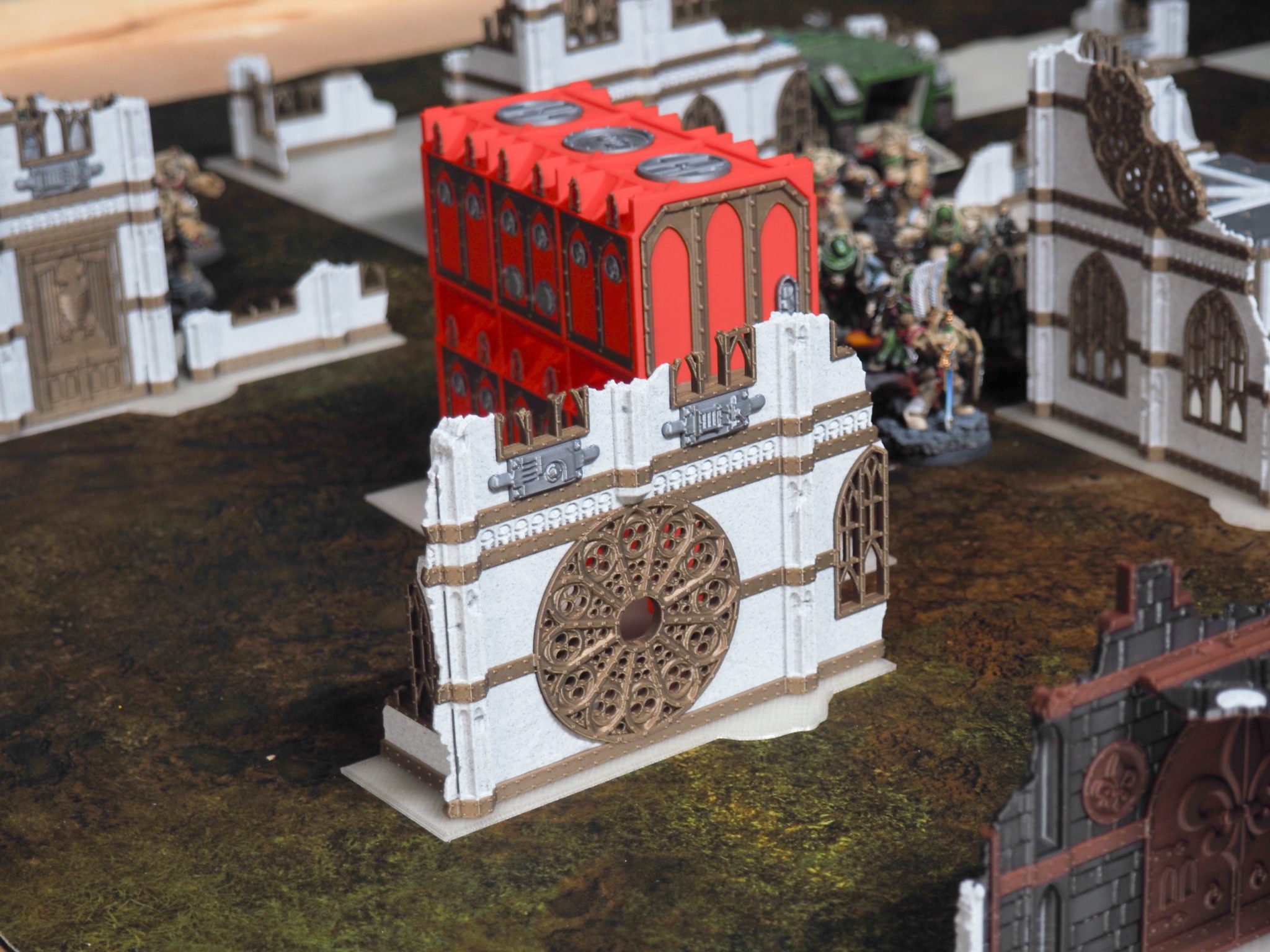 3D-printed Gothic ruined wall with rose window and red container used as tabletop wargaming terrain