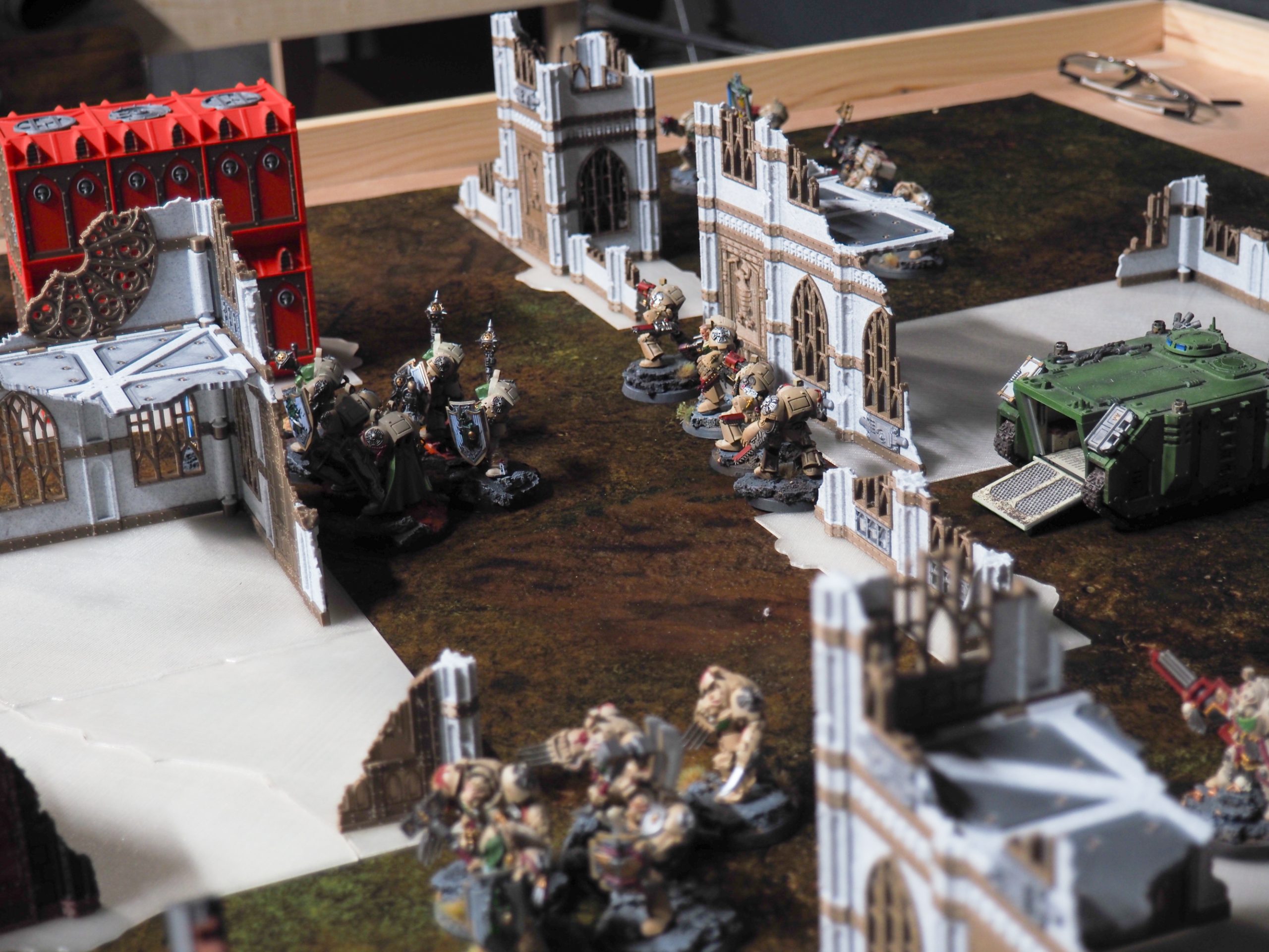 3D-printed ruined Gothic cathedral terrain set up on a tabletop gaming mat with painted miniature soldiers and a tank