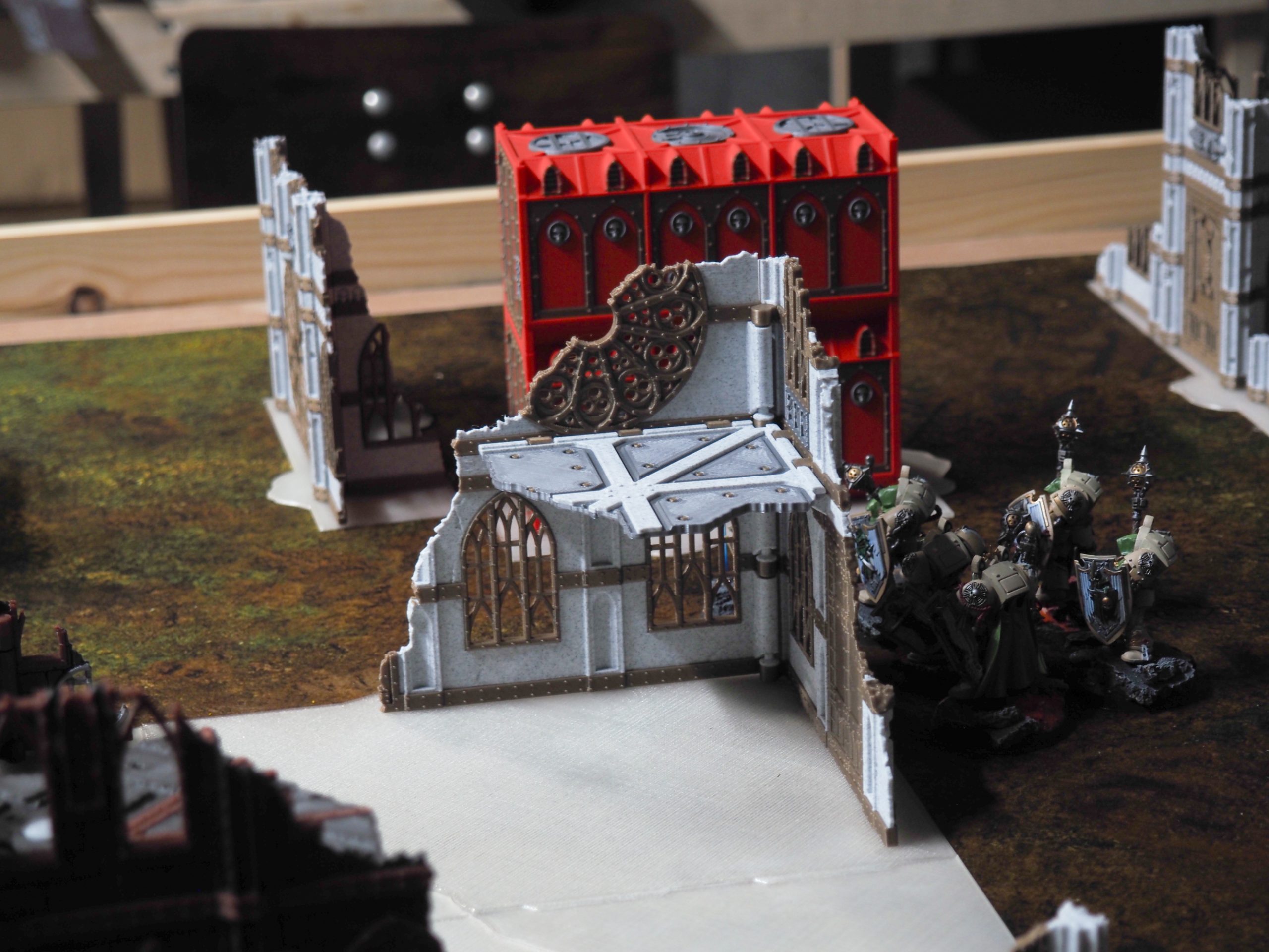 3D printed gothic ruin terrain piece for tabletop wargaming, shown on a battlefield mat with miniatures