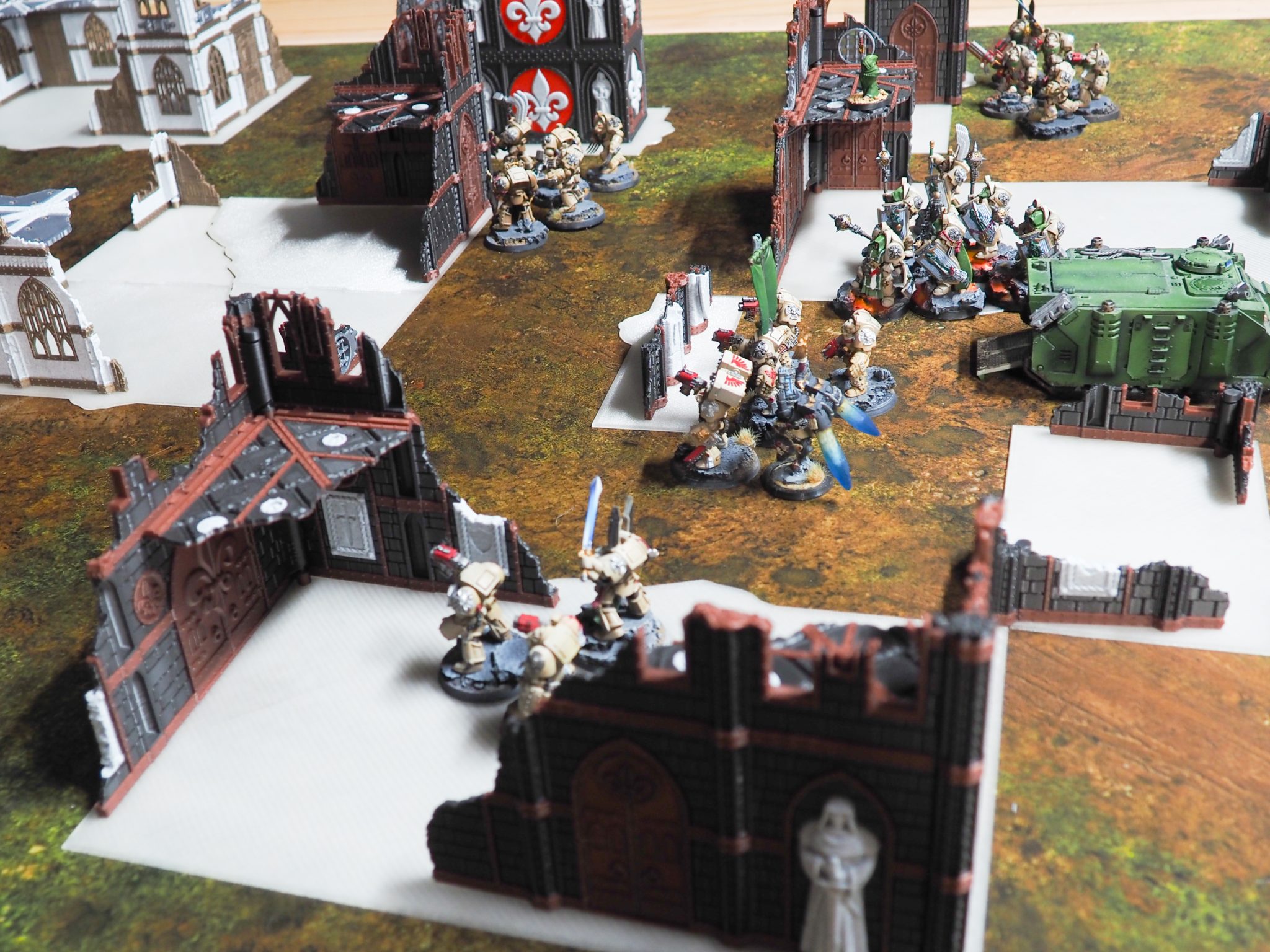 3D-printed gothic ruin terrain set up on a tabletop battle mat with painted sci-fi miniatures